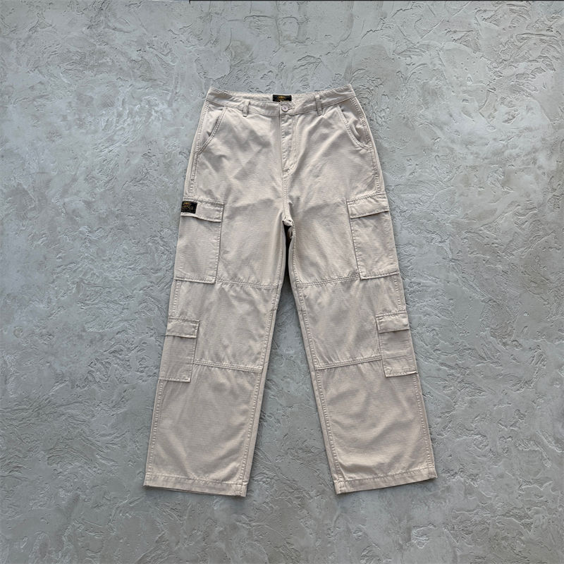 Tan Corteiz Guerillaz Cargo Pants laid flat, showing the full leg shape