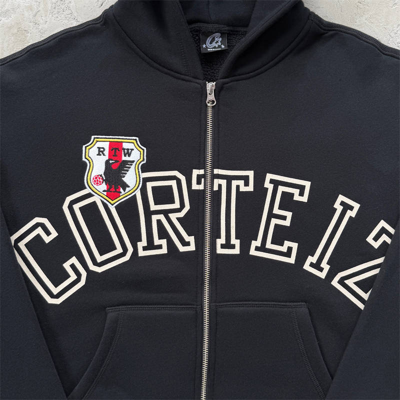 Black Corteiz Arch Shield Zip Hoodie chest lettering and front zip detail